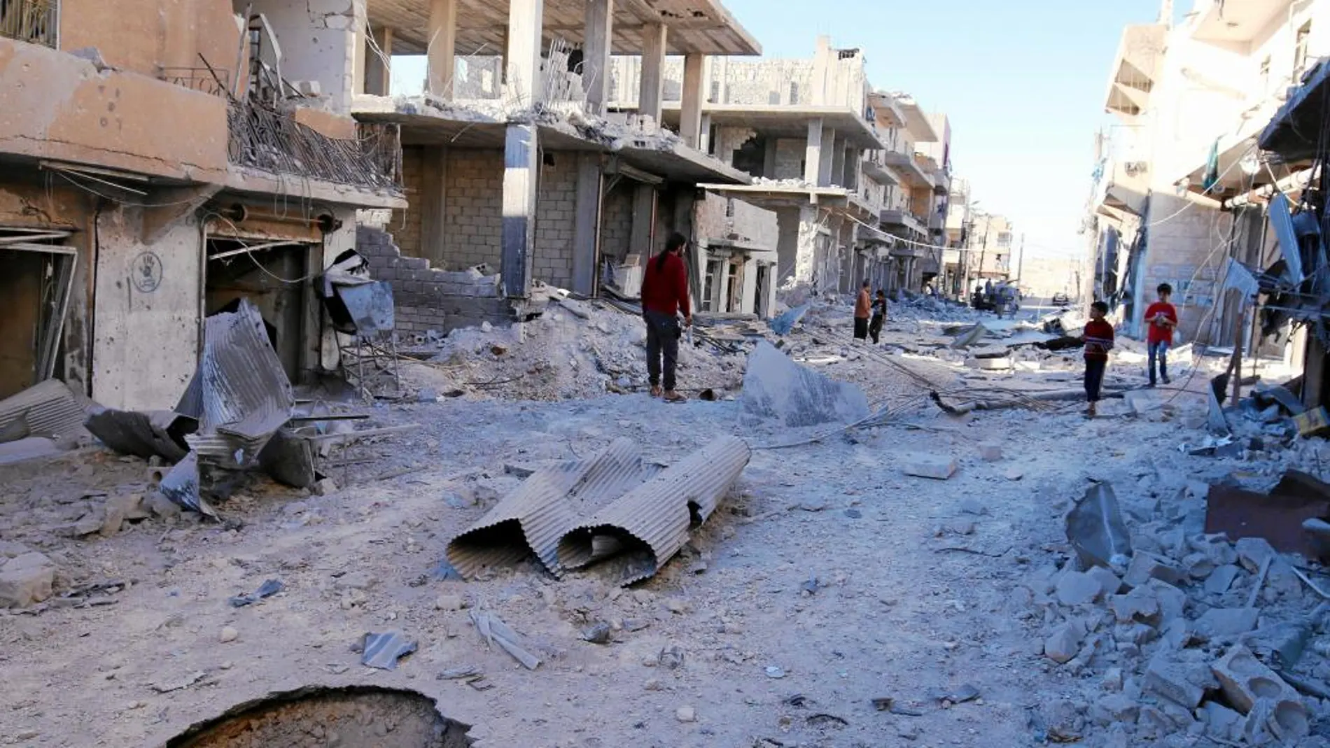 Vecinos del barrio rebelde de Sheikh inspeccionan los daños de las últimas bombas caídas ayer en la zona