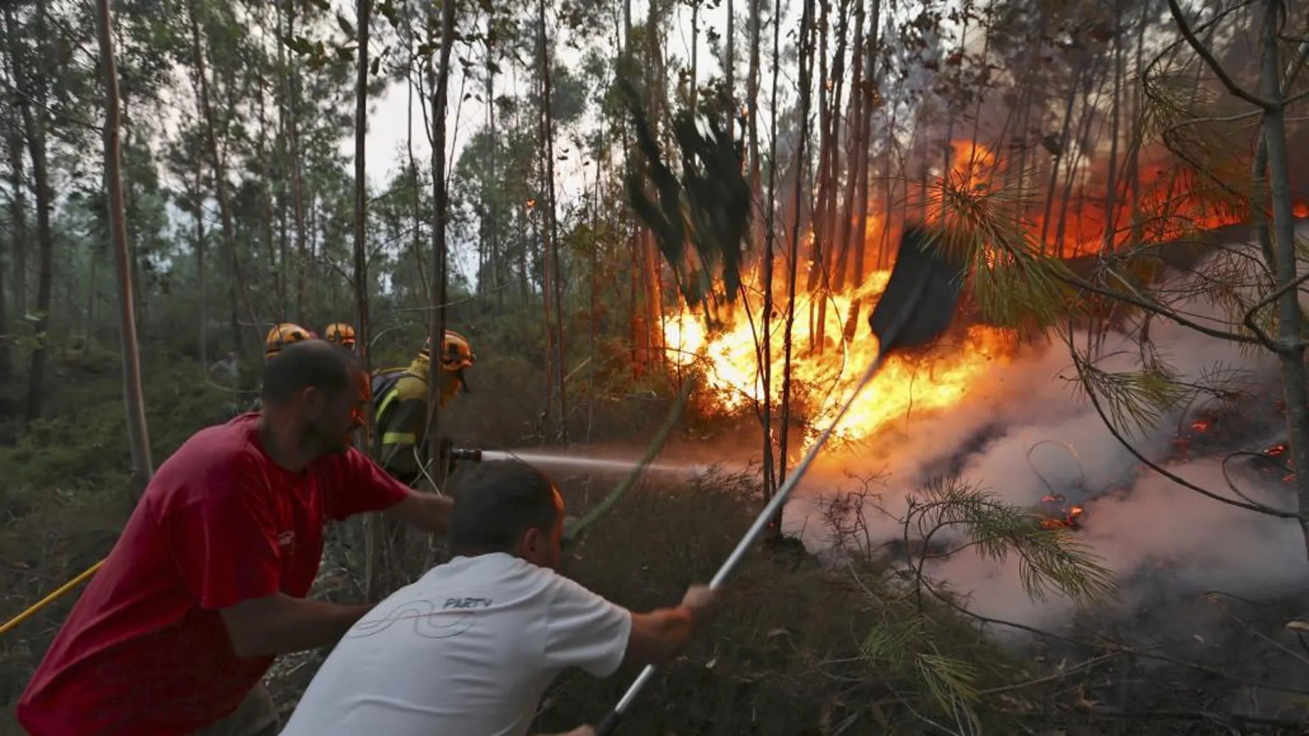 Varios vecinos intentan sofocar las llamas del incendio forestal de Arbo (Pontevedra)
