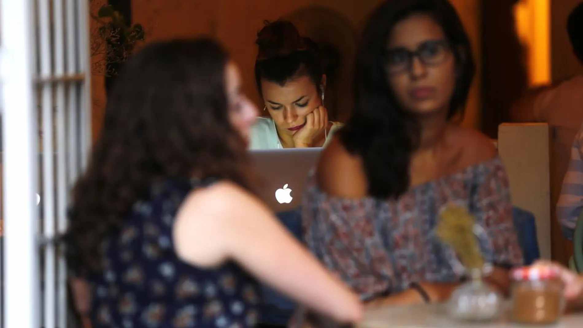 Una joven trabajando con su portátil en una cafetería de Madrid
