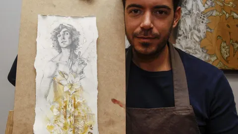 El autor Manuel Peña junto al cartel de la Asociación de Belenistas