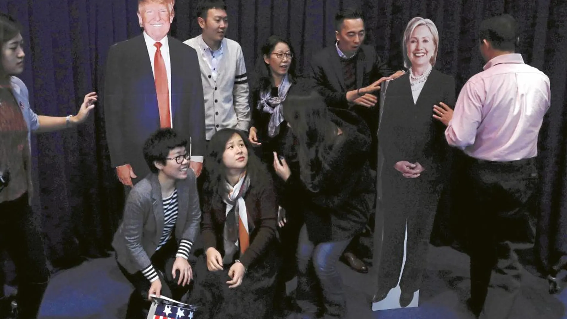Un grupo de chinos se fotografía con las imágenes de Clinton y Trump, durante la noche electoral en la Embajada de EE UU en Pekín
