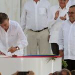 Juan Manuel Santos firma el acuerdo ante la mirada de Timochenko