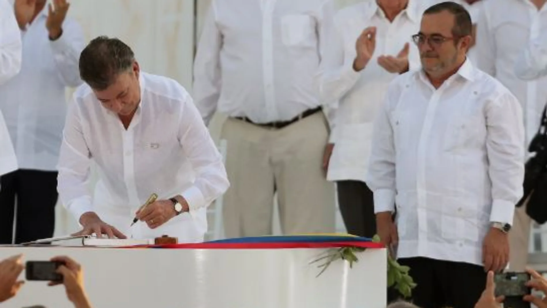 Juan Manuel Santos firma el acuerdo ante la mirada de Timochenko