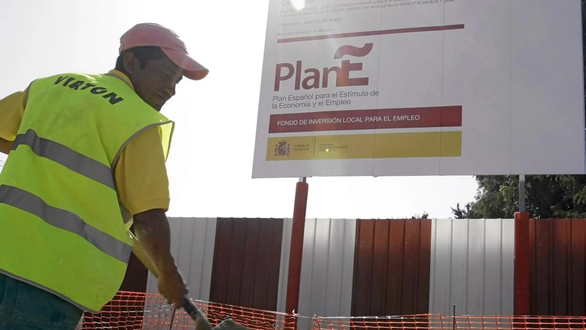 Un operario trabaja junto a uno de los carteles con los que el Gobierno de Zapatero promocionó el «Plan E»