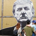 Unos habitantes de Atlanta contemplan un grafiti del presidente de Estados Unidos, Donald Trump, en el que aparece dibujado con el bigote de Hitler.