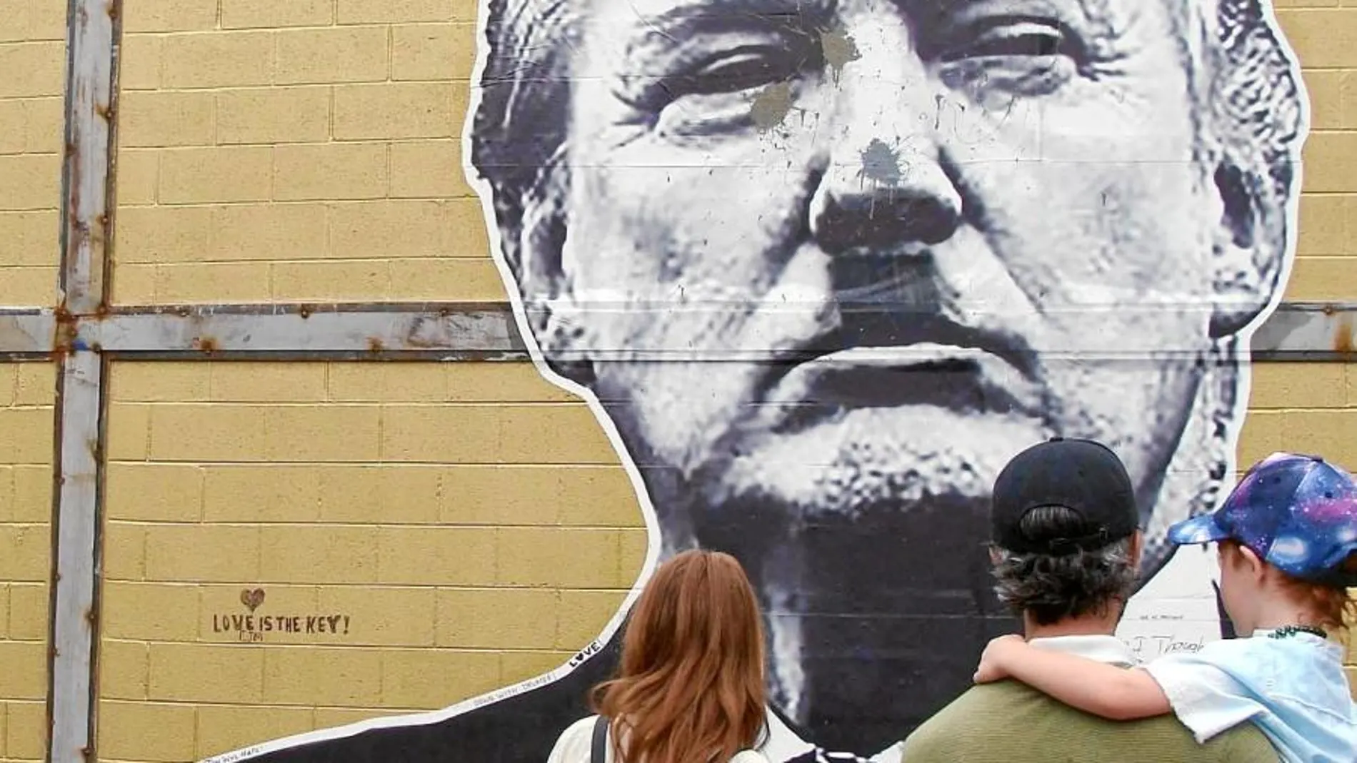 Unos habitantes de Atlanta contemplan un grafiti del presidente de Estados Unidos, Donald Trump, en el que aparece dibujado con el bigote de Hitler.