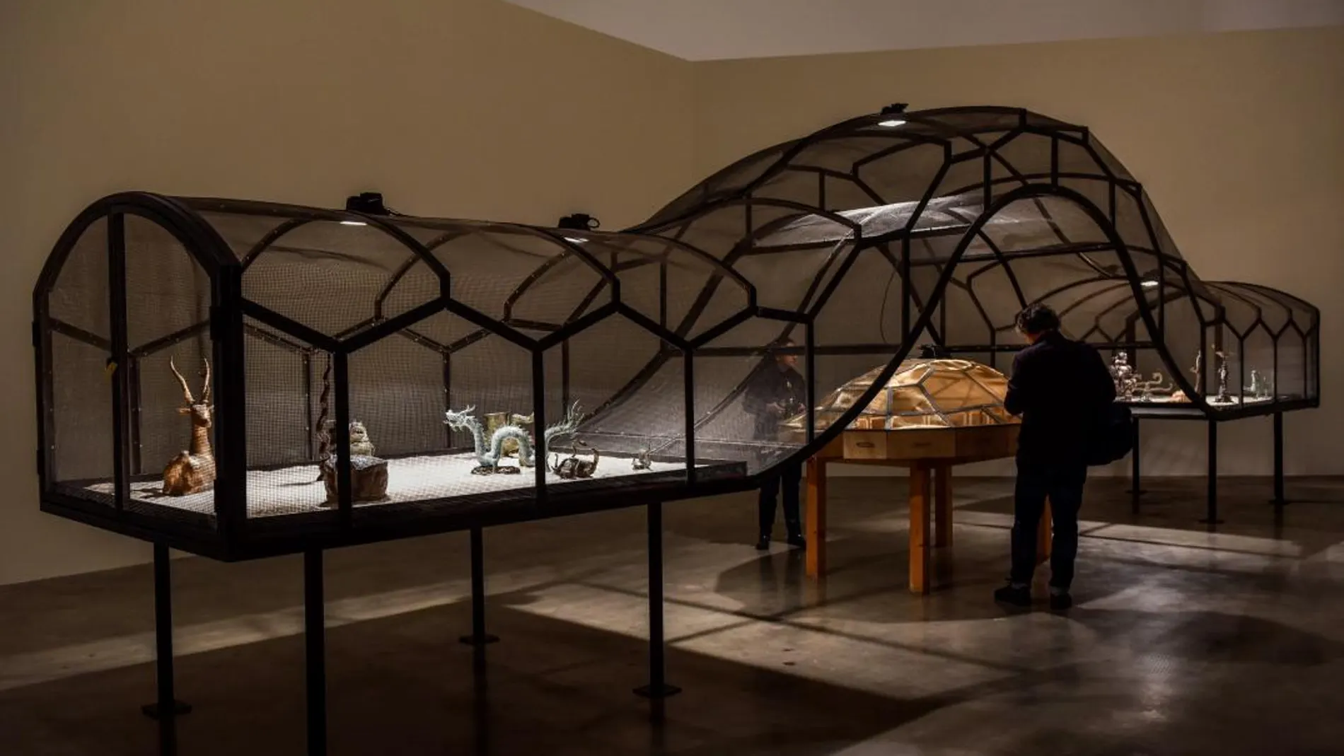 Un hombre observa «El teatro del Mundo» (1993) del artista Huang Yong Ping y con animales e insectos vivos, que forma parte de la muestra "Arte y China después de 1989: el teatro y el mundo", que se expone en el Museo Guggenheim Bilbao / Efe