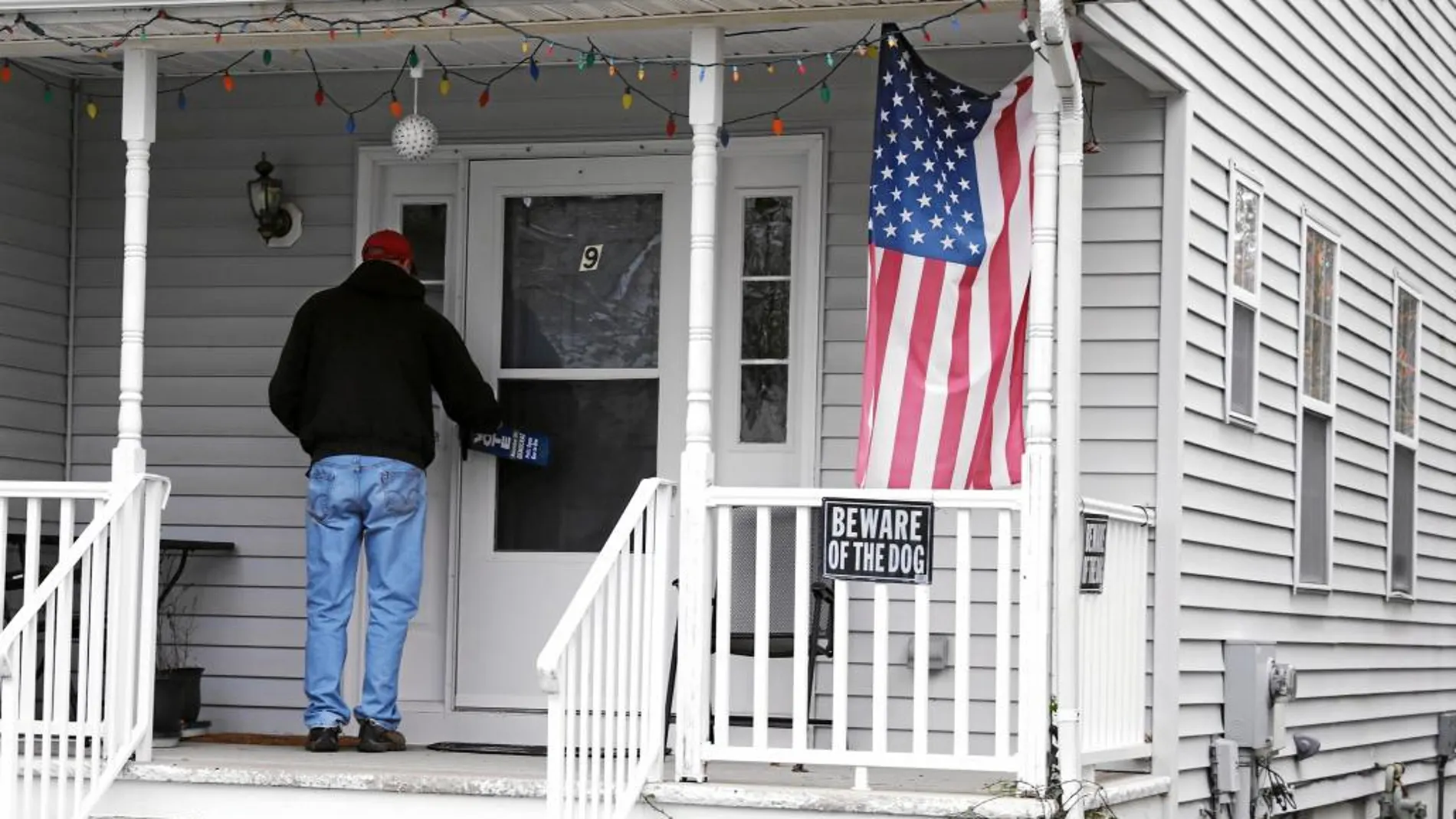 Un activista deja carteles en las casas de Lawrence para animar a votar