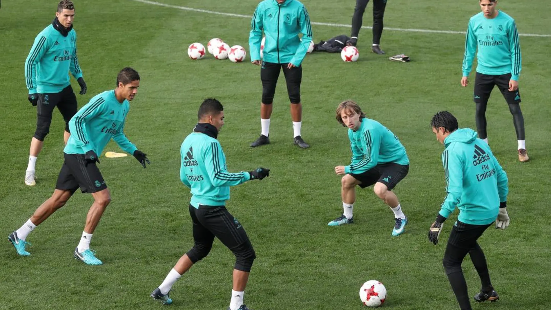 Los jugadores del Real Madrid, el croata Luka Modric (3d), y el portugués Cristiano Ronaldo(1i), durante la sesión de entrenamiento celebrada ayer.