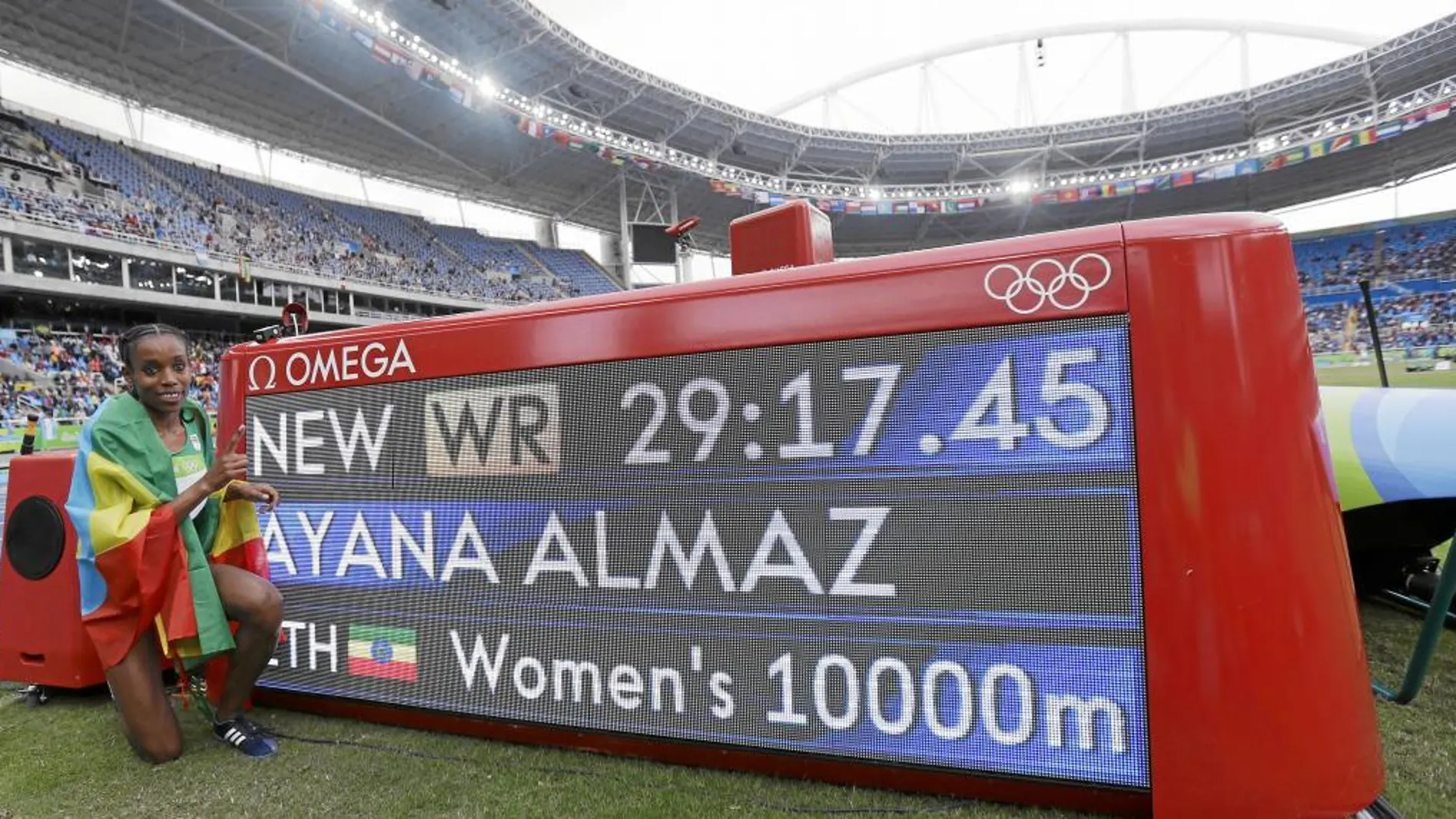 Almaz Ayana posa junto al marcador que anuncia su nuevo récord del mundo