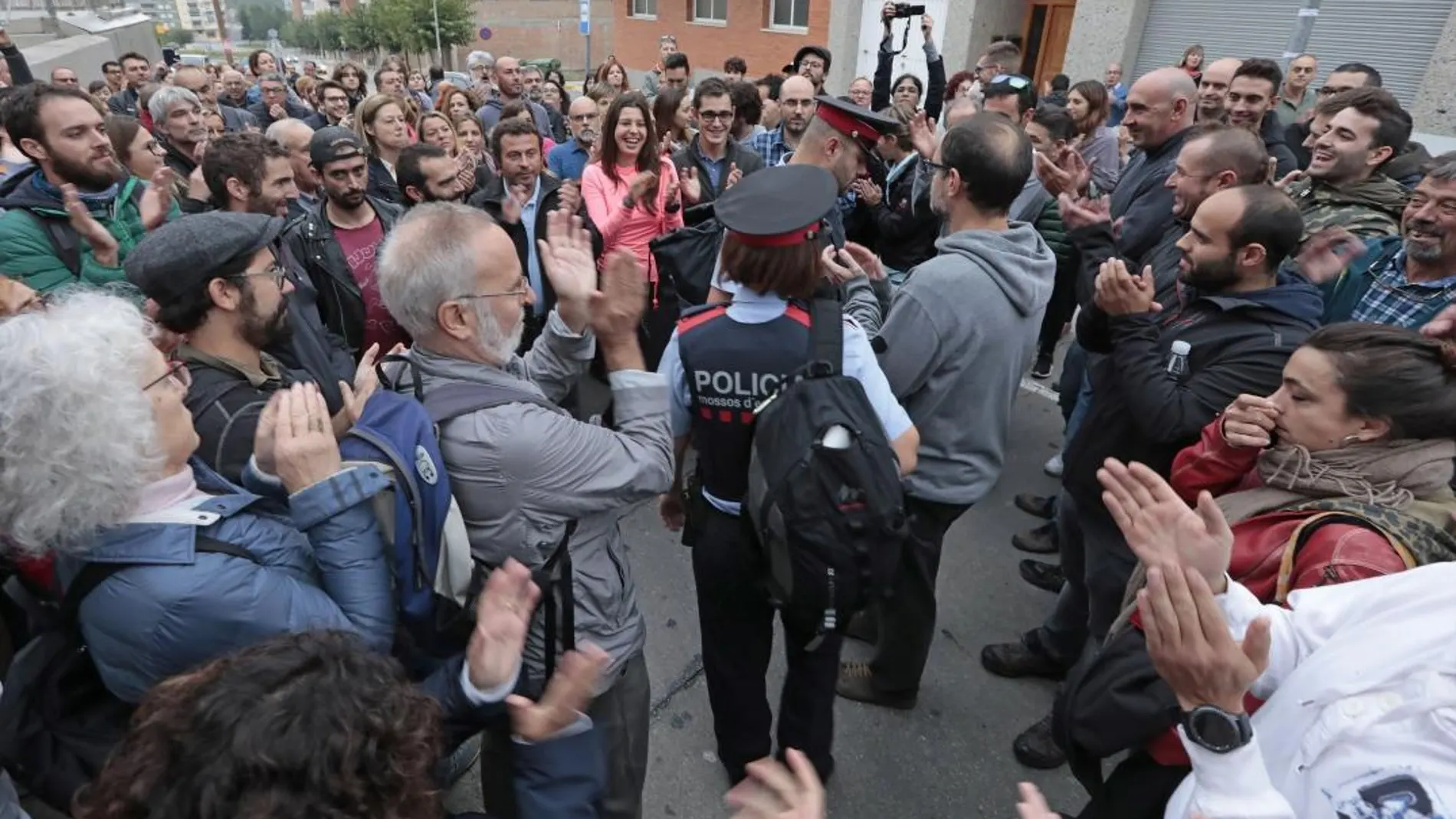 Personas que acudían a votar al IES Montbui, de Santa Margarida de Montbui (Barcelona), aplauden a los Mossos d'Esquadra por su inacción. EFE/Susanna Sáez