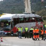 Diversos operarios tras levantar el autocar perteneciente a la empresa de Mollet del Vallès (Barcelona)