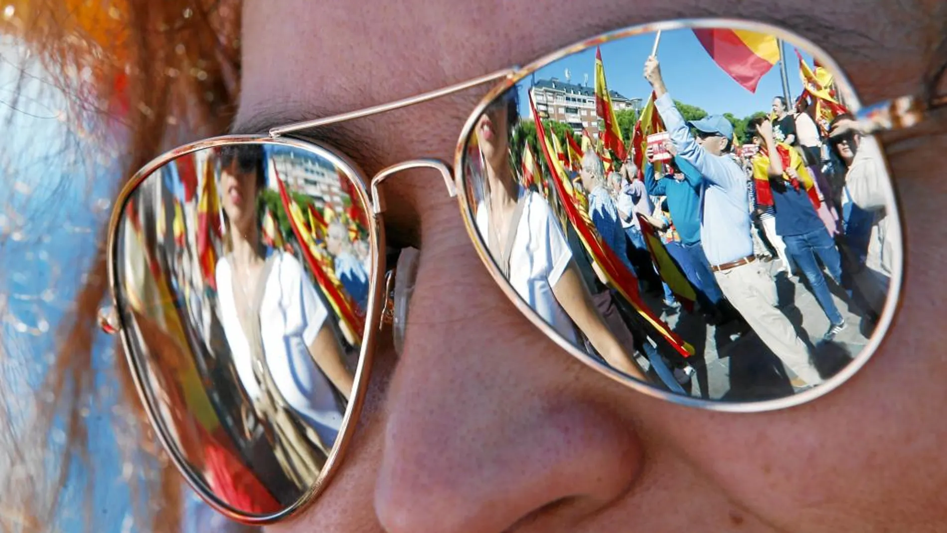 La manifestación de ayer en la Plaza de Colón por la unidad de España reflejada en las gafas de una asistente