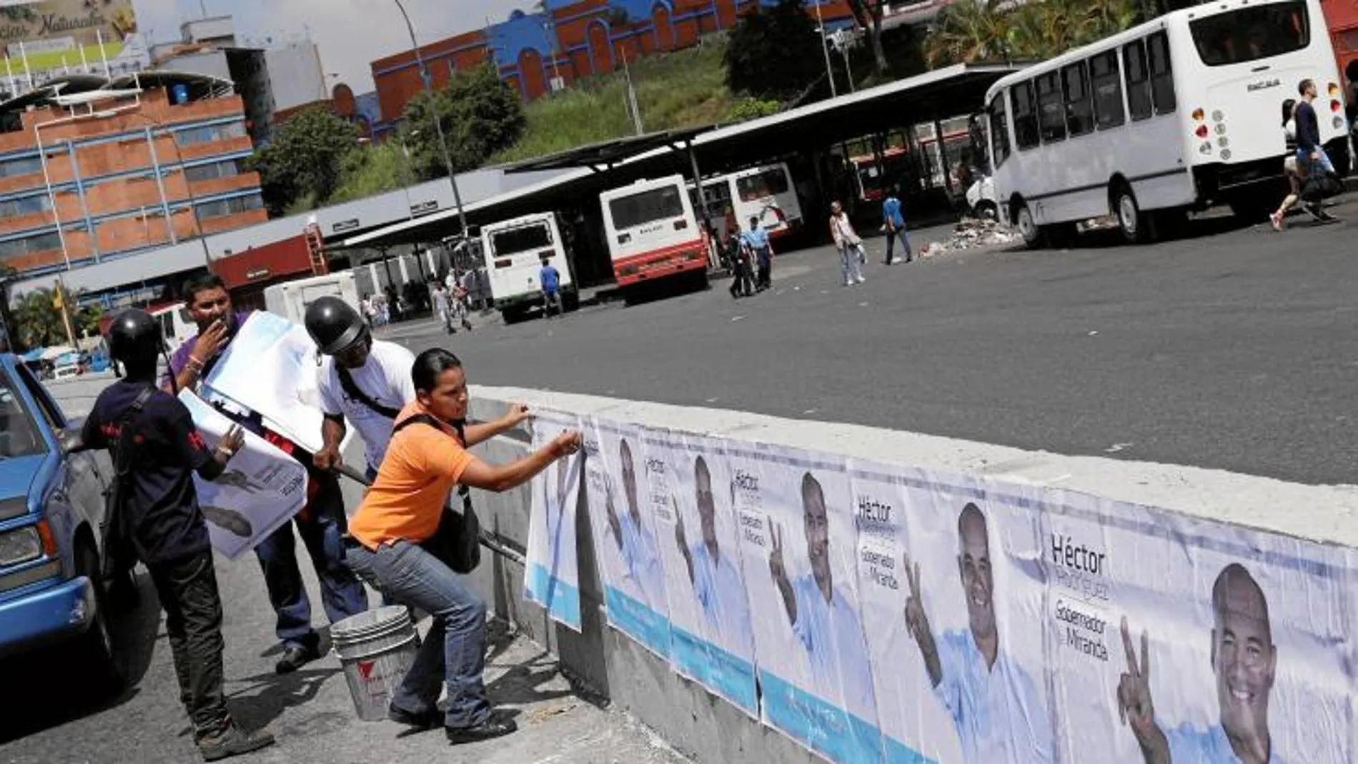 Seguidores de Héctor Rodriguez pegan carteles electorales en el estado de Miranda donde era gobernador Henrique Capriles