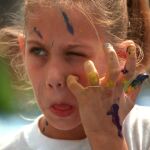 Una chica se rasca por el picor que le causa la pintura en la cara /AP