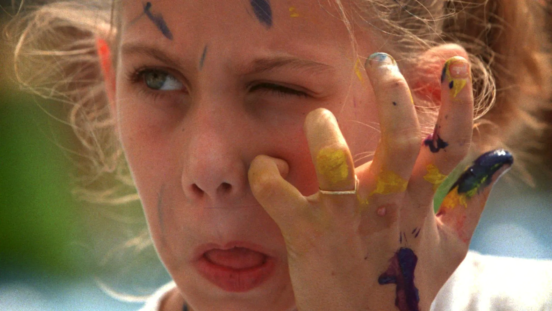 Una chica se rasca por el picor que le causa la pintura en la cara /AP
