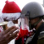 Un manifestante palestino vestido de Santa Claus se encara a un soldado israelí, ayer, en Belén