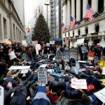 Varias personas protestan contra la reforma fiscal republicana junto a la Bolsa de Wall Street en Nueva York