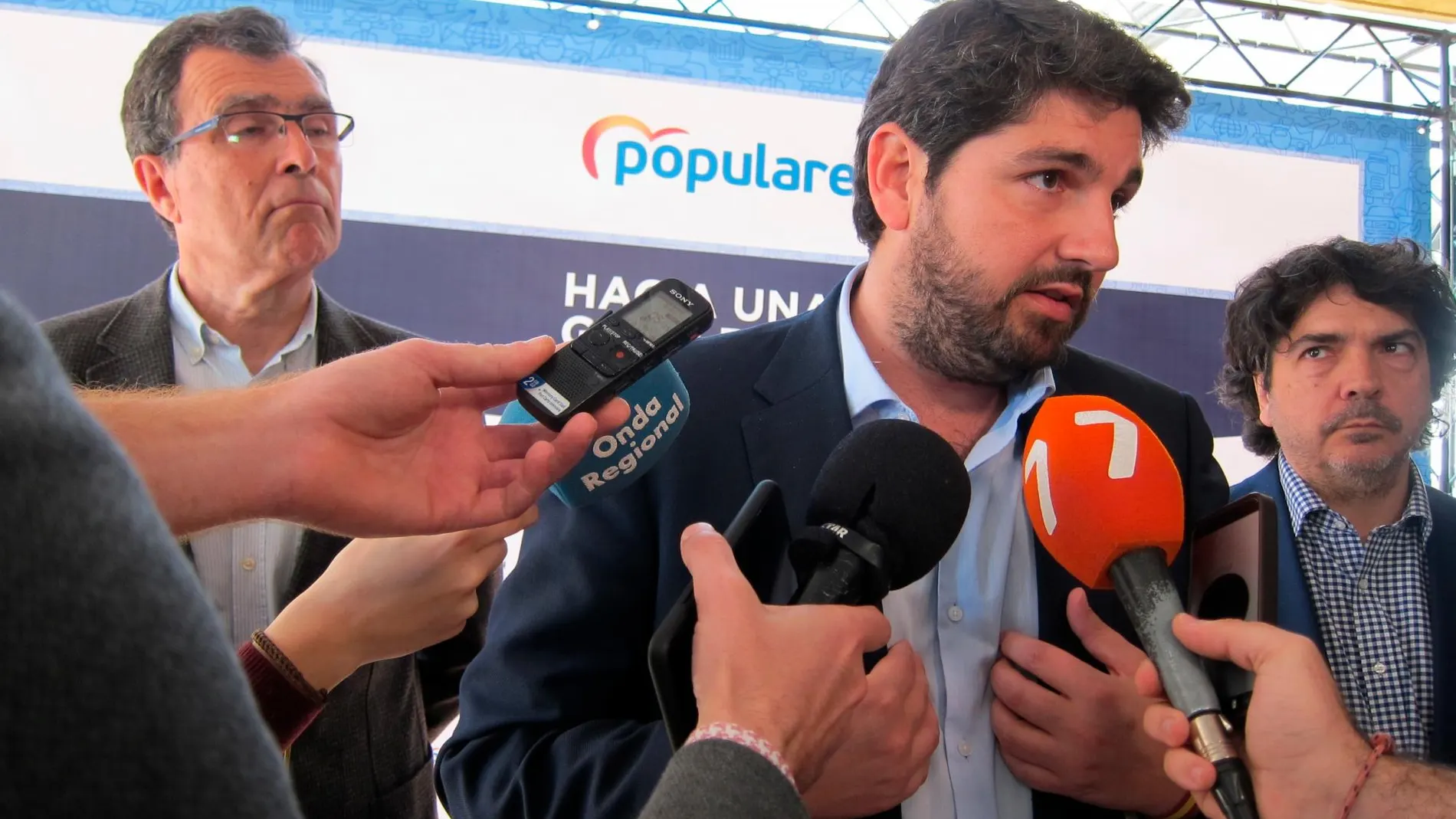 El presidente regional del PP, López Miras, atiende a los medios de comunicación bajo la mirada del candidato a la alcaldía de Murcia, José Ballesta. EUROPA PRESS