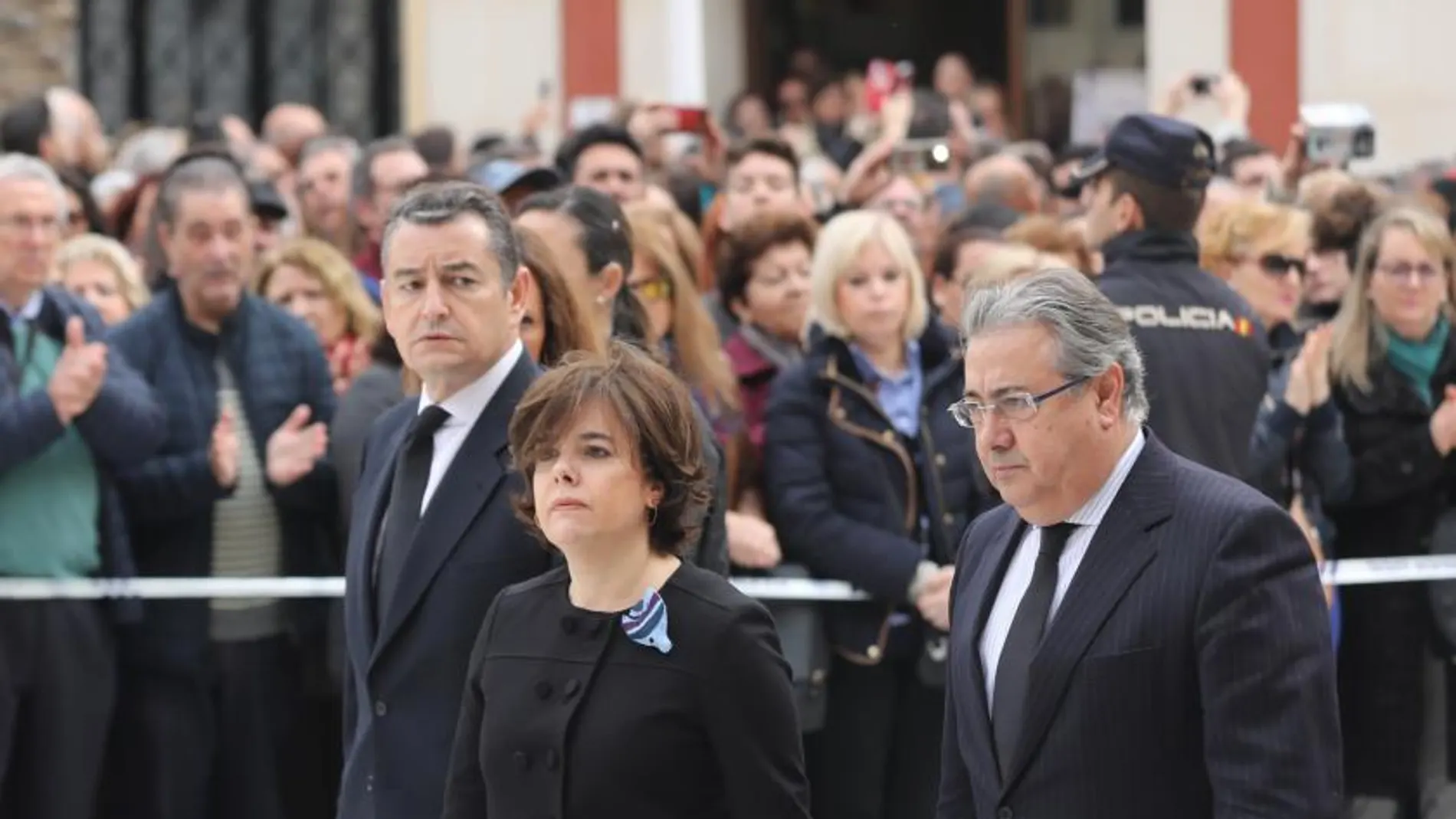 Soraya Sáenz de Santamaría y Juan Ignacio Zoido, que lleva la bufanda de Gabriel en la mano, a su llegada al funeral por Gabriel