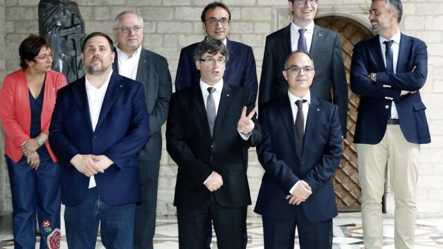 El vicepresidente y conseller de Economía, Oriol Junqueras; el presidente de la Generalitat, Carles Puigdemont; y el de Presidencia y portavoz del Govern, Jordi Turull, (segunda fila, de i a d) la de Trabajo, Dolors Bassa; el de Cultura, Lluís Puig; el de Territorio, Josep Rull; el de Justicia, Carles Mundó; y el de Empresa, Santi Vila