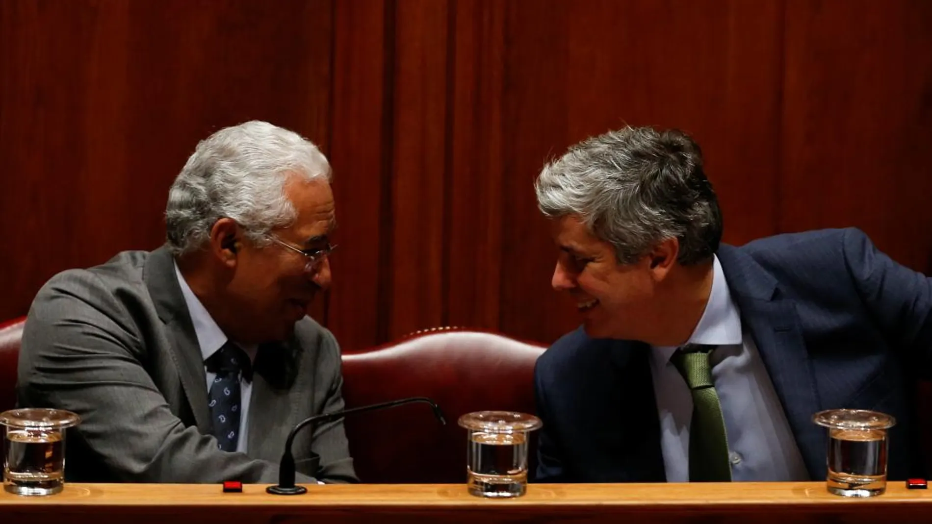 El primer ministro luso, Antonio Costa, conversa con el ministro de Finanzas portugués, Mario Centeno (dcha) durante un debate en el Palramento de Losboa el pasado día 27