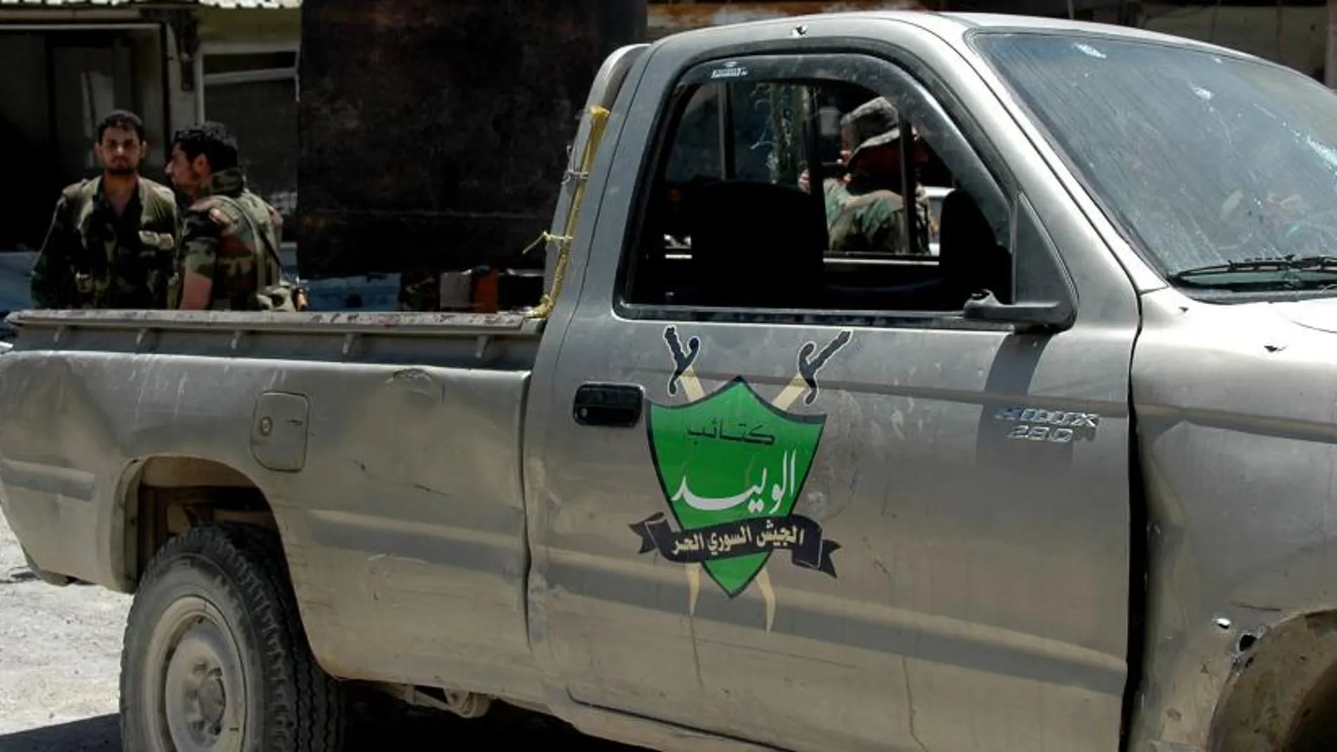 Soldados sirios permanecen junto a un vehículo al parecer abandonado por rebeldes en la localidad estratégica de Al Quseir