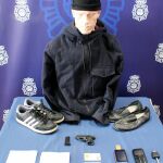 Indumentaria de uno de los atracadores, con el arma de fuego que empleaba