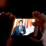 Un simpatizante observa un vídeo del ex president