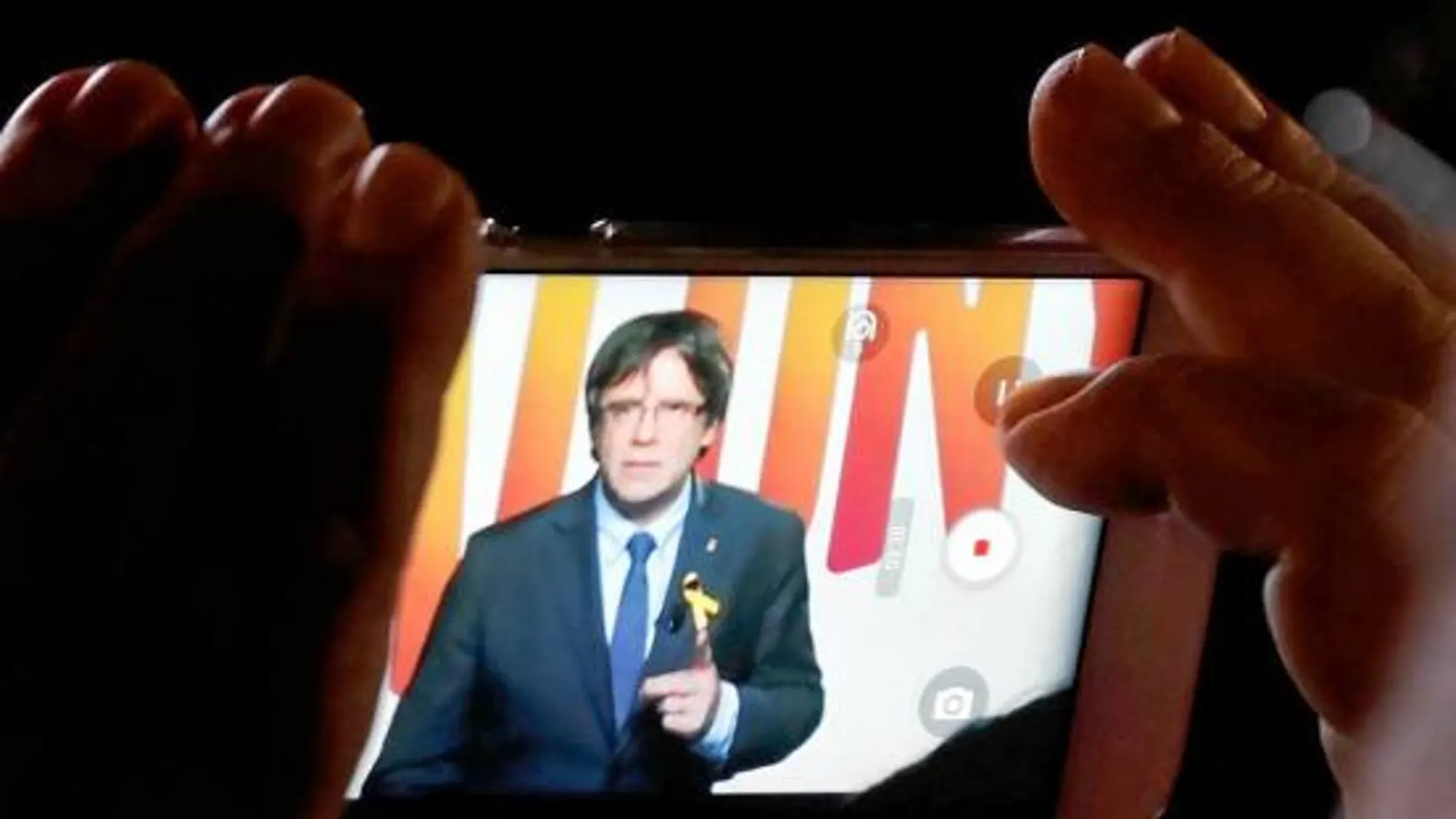 Un simpatizante observa un vídeo del ex president