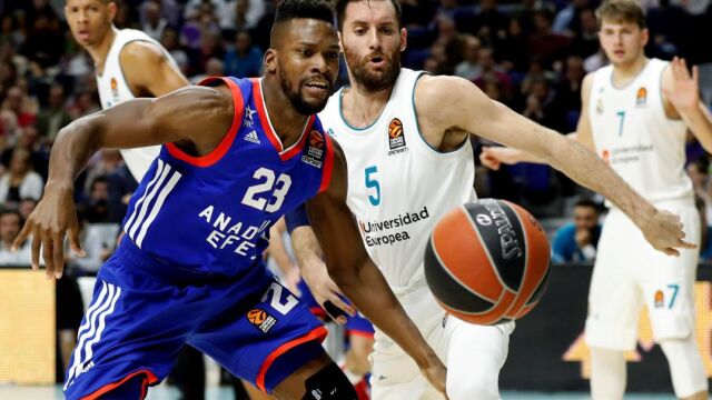 El alero del Real Madrid Rudy Fernández (d) lucha el balón con el base estadounidense Toney Douglas