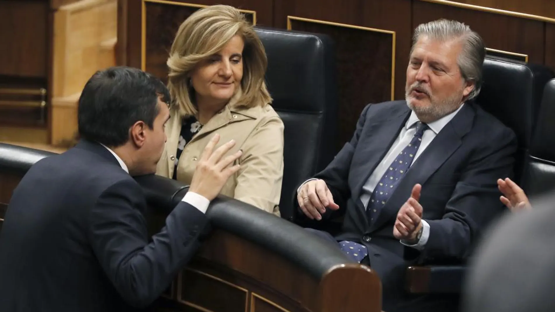 La ministra de Empleo, Fátima Báñez (c), y el de Educación, Íñigo Méndez de Vigo (d), conversan con el diputado del PP, José Luis Ayllón (i), esta tarde en el pleno del Congreso de los Diputados