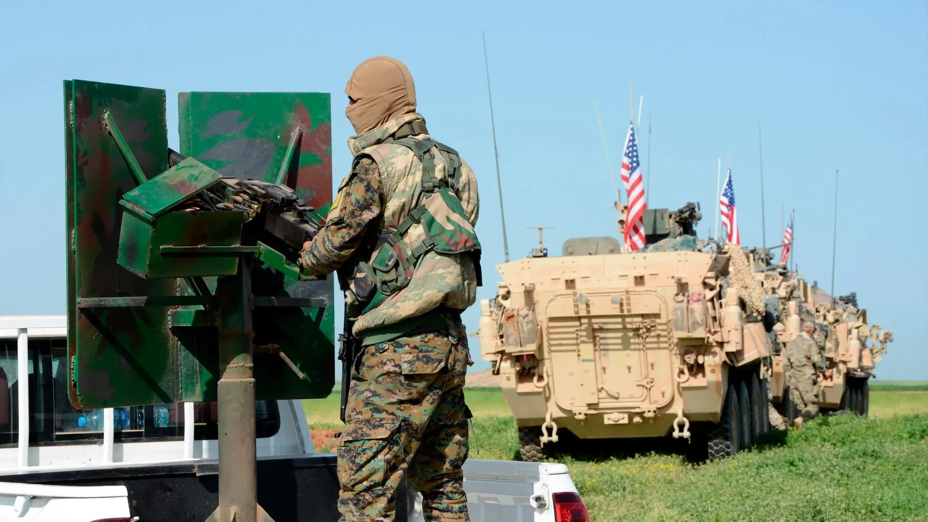 Tropas estadounidenses (d) junto a una milicia del grupo kurdo Unidades de Protección Popular (YPG) mientras patrullan en la ciudad al-Darbasiyah, en la frontera sirio-turca,