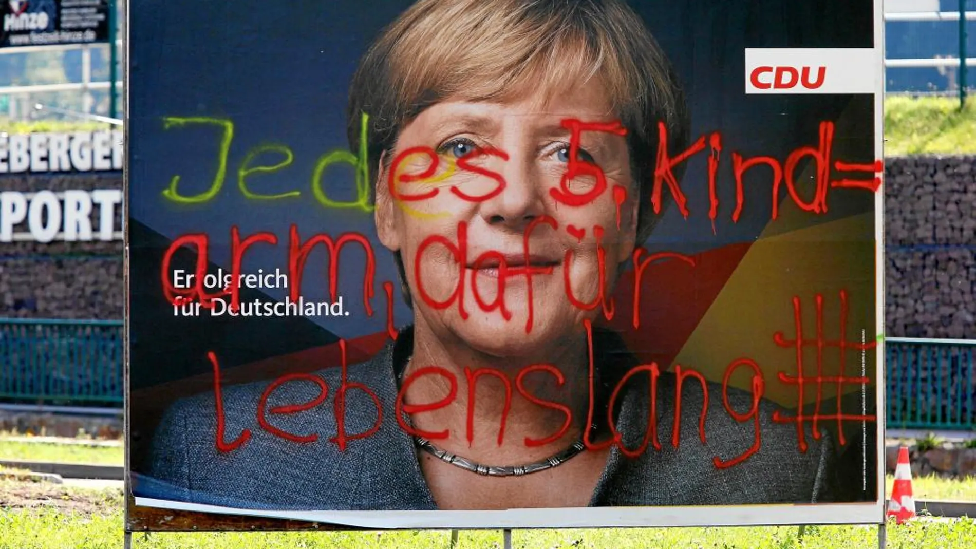 Un graffiti en un cartel de la canciller Angela Merkel protesta contra la pobreza infantil en Alemania