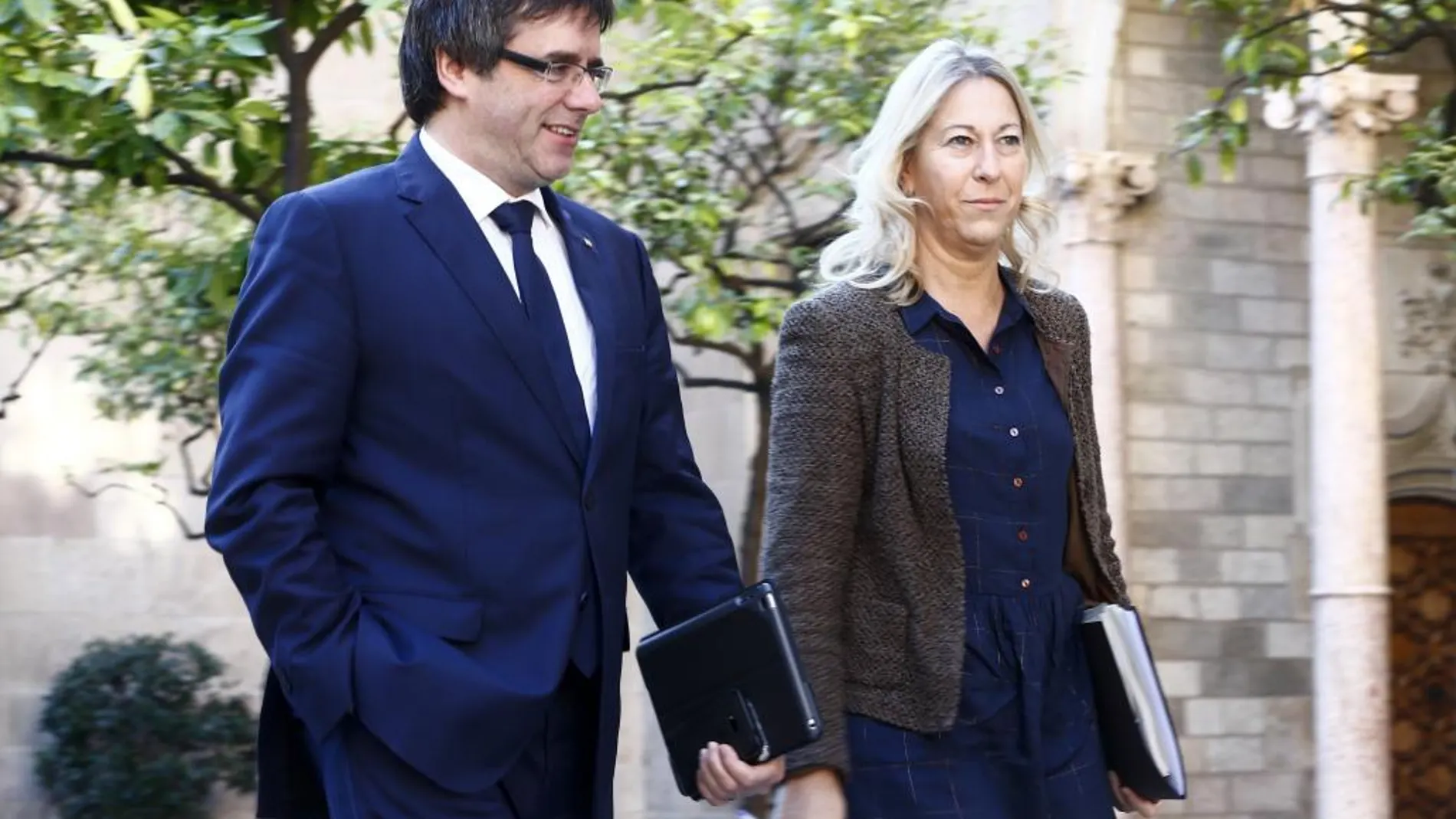 El presidente de la Generalitat, Carles Puigdemont (i), y la consejera de la Presidencia, Neus Munté (d), se dirigen a la reunión del gobierno de Cataluña.