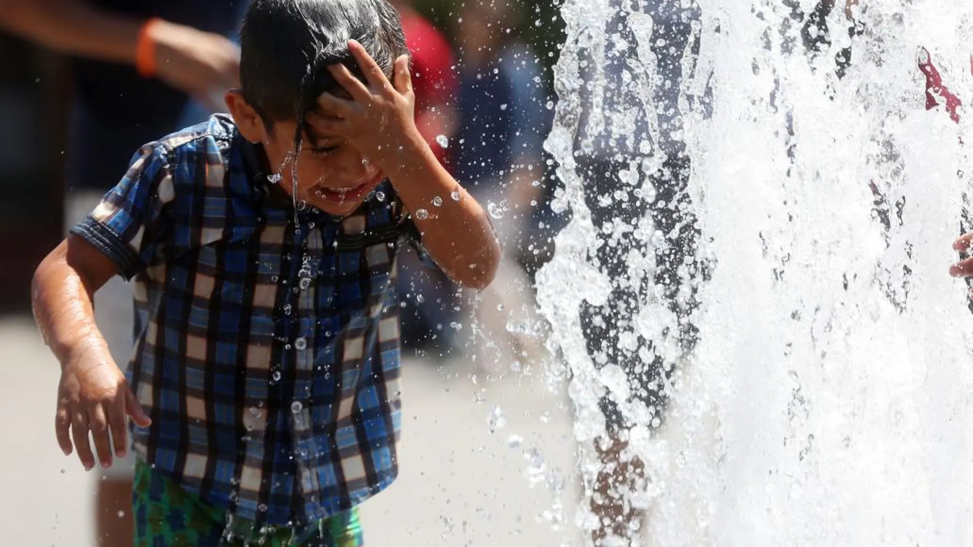 Un niño se refresca el pasado 14 de diciembre en las calles de Santiago (Chile), durante días de temperaturas extremas.