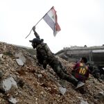 Un soldado coloca una bandera siria en la primera línea de fuego de Ramouseh, el este de Alepo