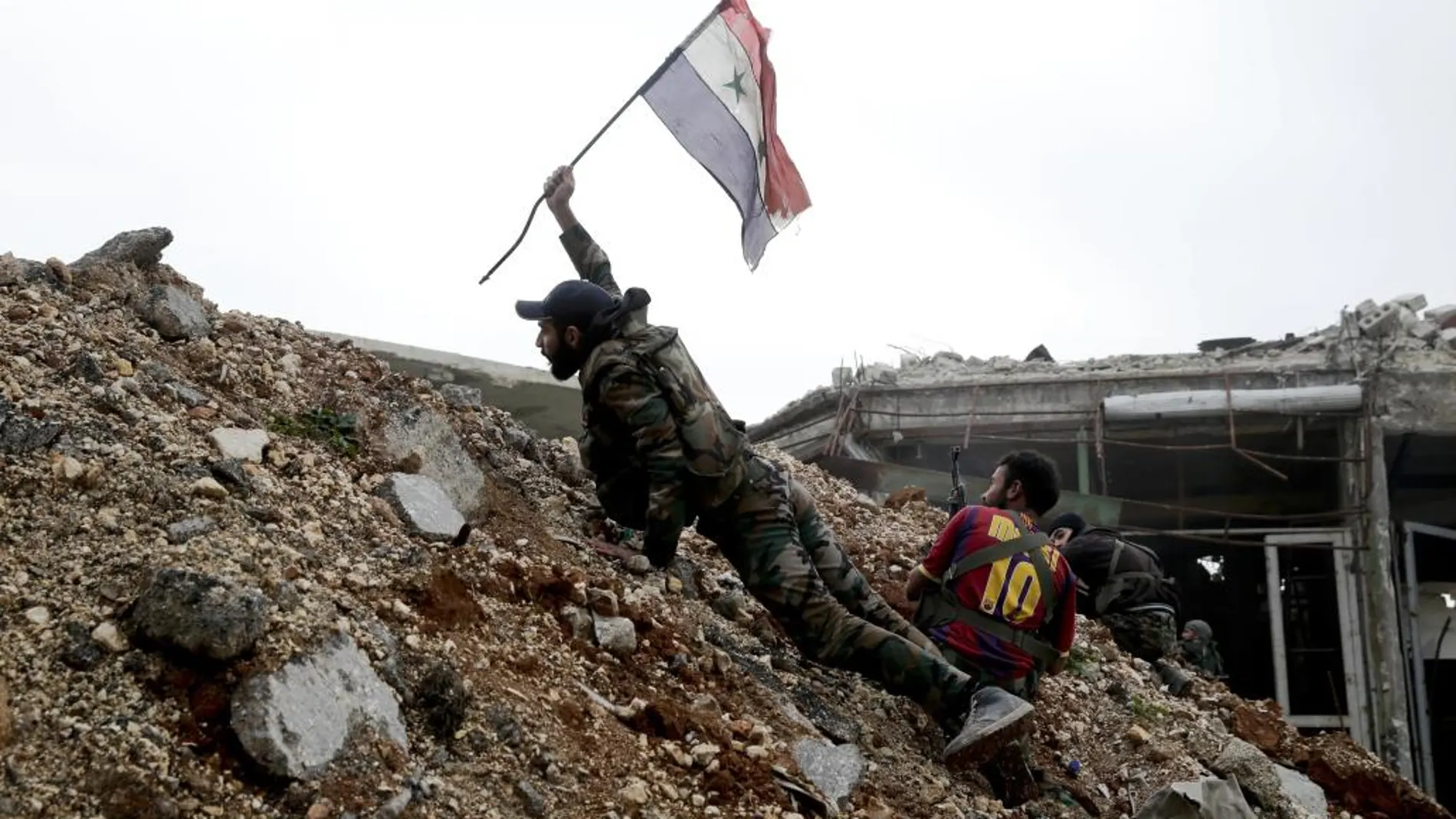 Un soldado coloca una bandera siria en la primera línea de fuego de Ramouseh, el este de Alepo