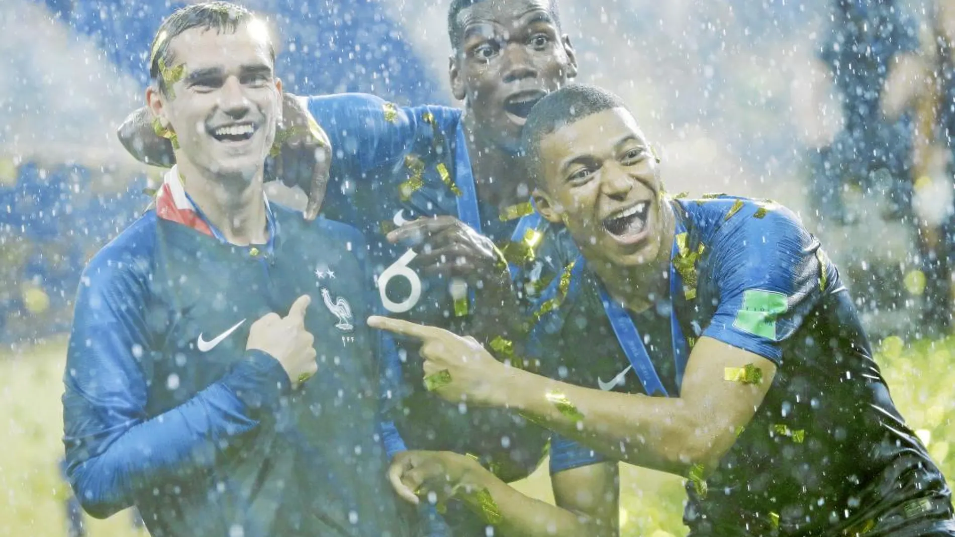 Pogba, Griezmann y Mbappé celebran el triunfo señalando el gallo del escudo