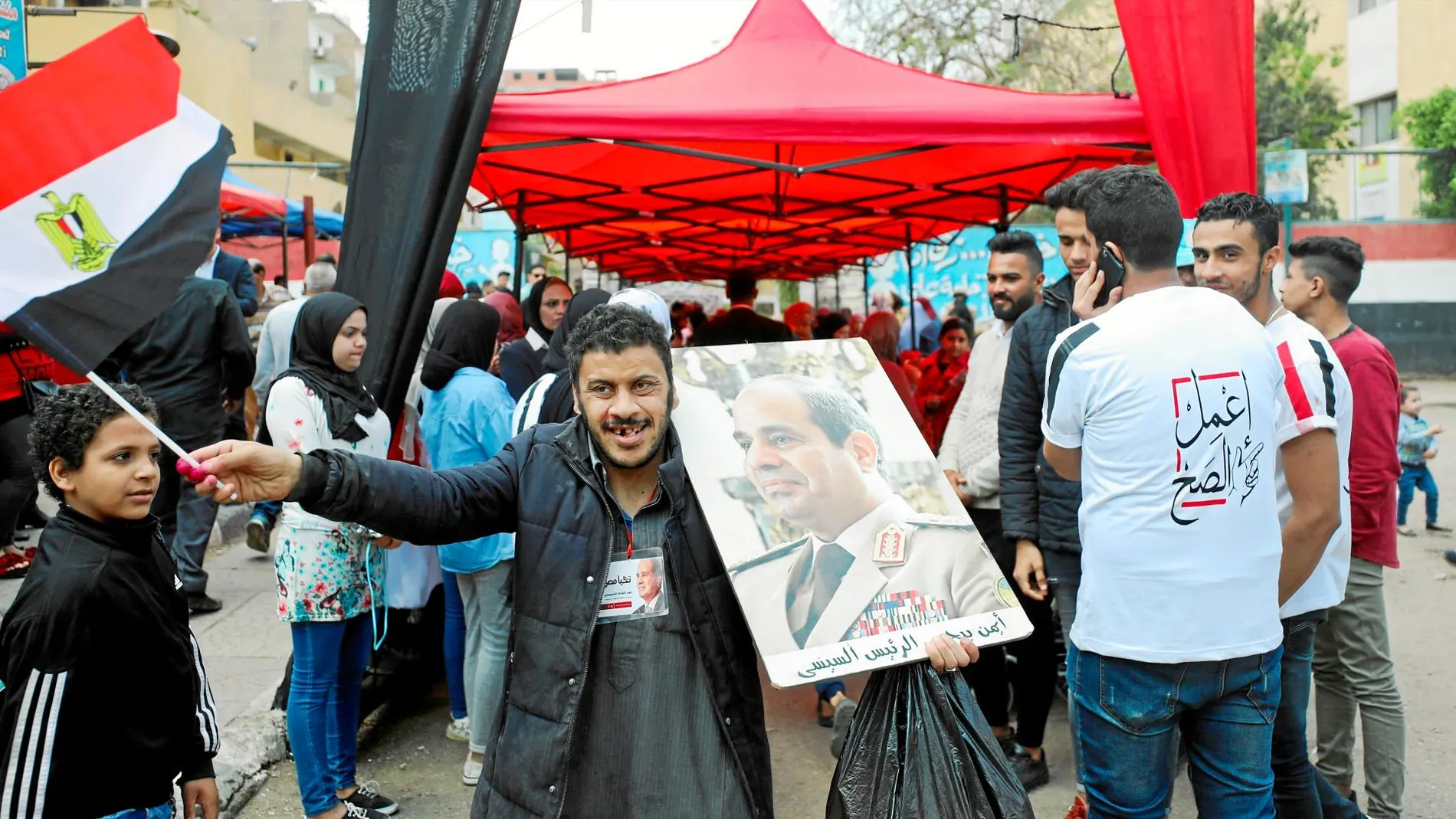 Un hombre sostiene un cartel con la imagen del presidente Al Sisi a la salida de un colegio electoral en El Cairo / Reuters