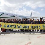 El Villarreal, con una pancarta por el cuarto aniversario de la apertura de vuelos comerciales en el aeropuerto de Castellón. Al fondo, su lujoso avión