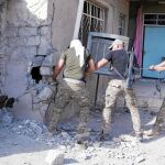 Las fuerzas especiales iraquíes arrastran el cadáver de un combatiente del EI cerca de Karamah, en Mosul, ayer