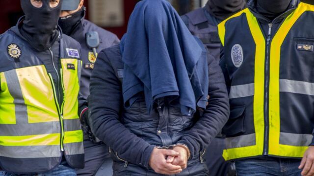 Efectivos de la Policía Nacional trasladan al detenido en Aranjuez tras el registro de su domicilio