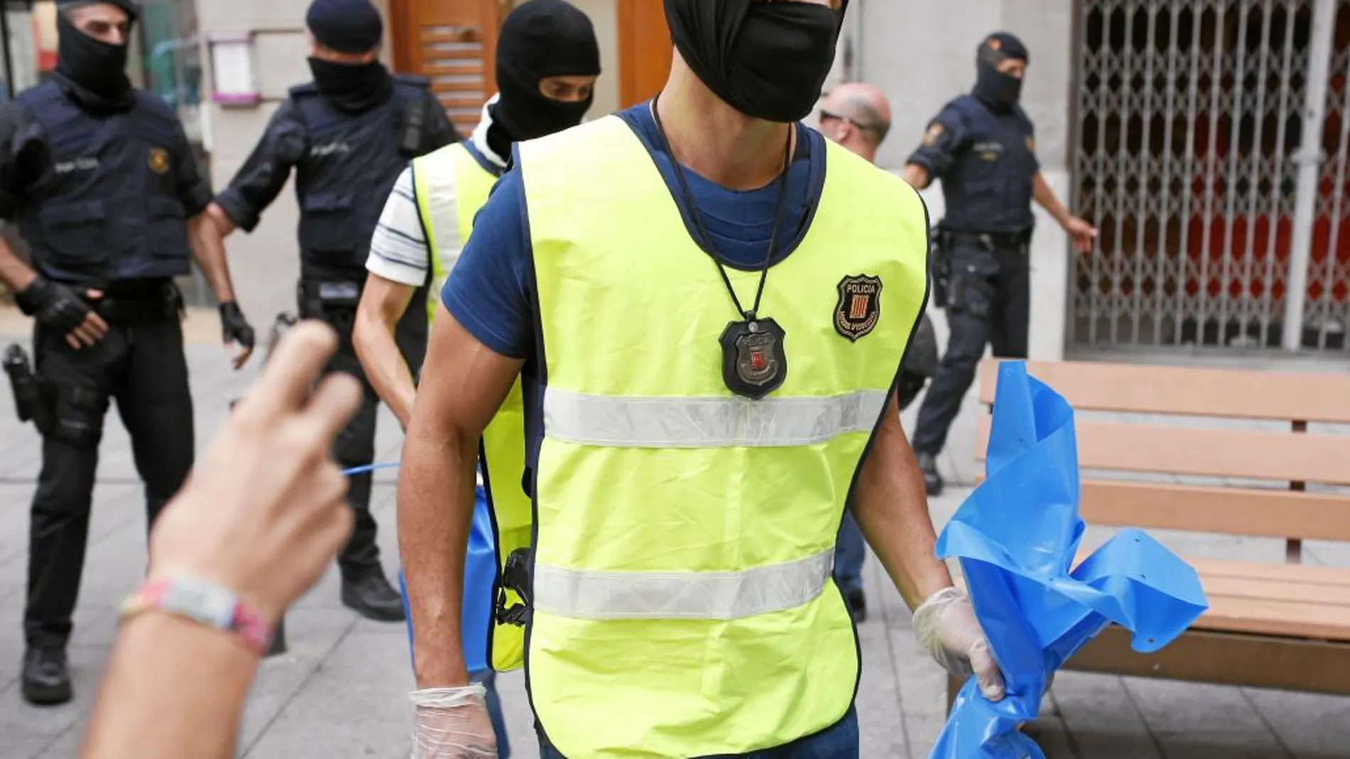 Agentes de los Mossos se llevan pruebas tras los registros realizados en Barcelona