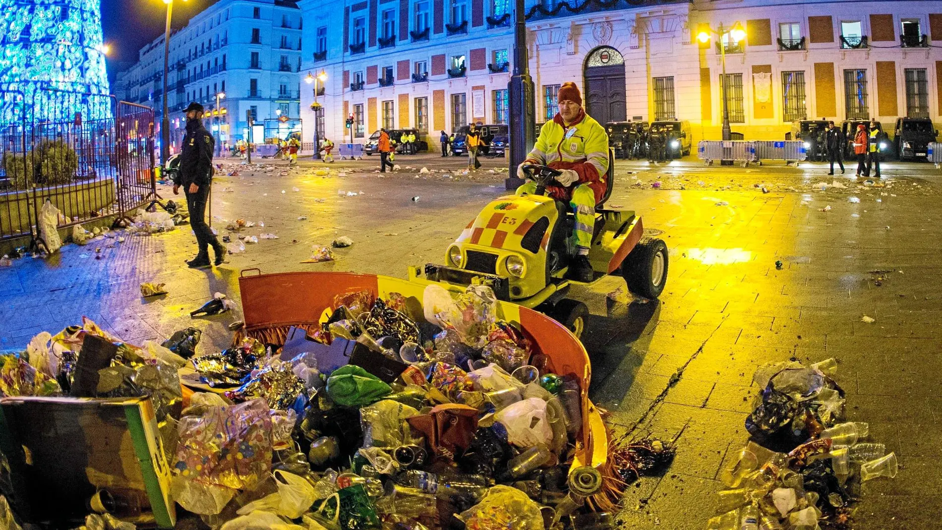 Un operario de los servicios de limpieza retira los restos de la fiesta en la Puerta del Sol