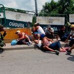 Un grupo de personas se protegen de los disparos en el puente internacional Simón Bolívar / Reuters