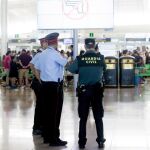 Agentes de la Guardia Civil se coordinan con los Mossos d'Esquadra (iz) en los alrededores de los accesos a las puertas de embarque en el aeropuerto de Barcelona