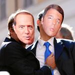 Dos simpatizantes del Movimiento 5 Estrellas exhiben caretas de Berlusconi y Renzi, promotores de la ley electoral