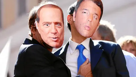 Dos simpatizantes del Movimiento 5 Estrellas exhiben caretas de Berlusconi y Renzi, promotores de la ley electoral