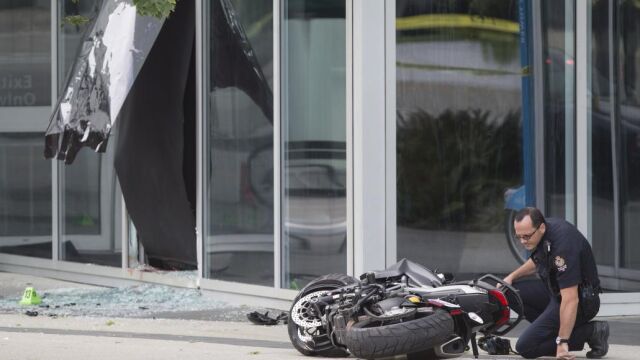 Un policía examina la moto que conducía la especialista
